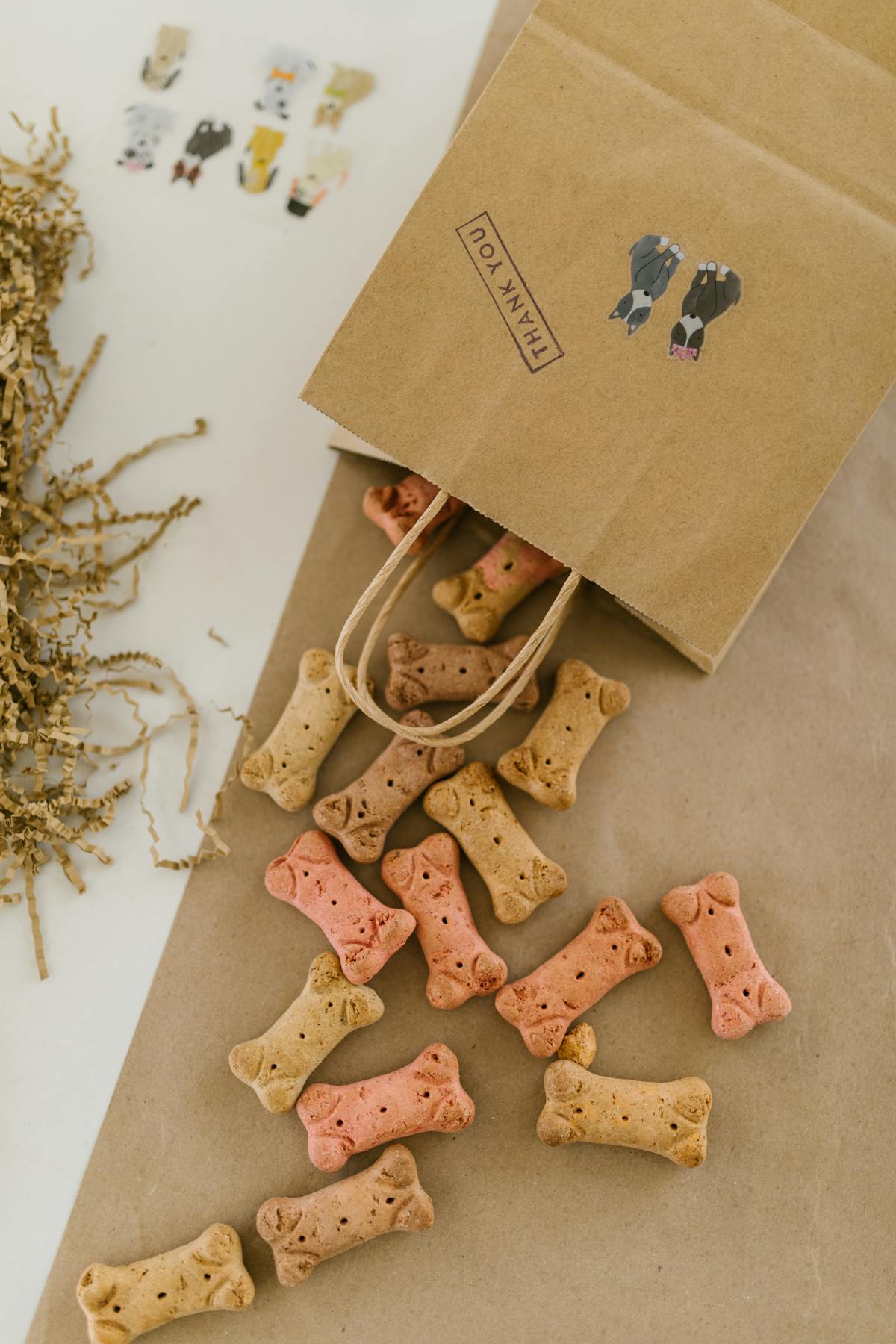 Small kraft paper bags filled with dog treats and tied with ribbon, arranged on a party table